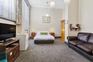 a hotel room with a bed and a couch at Vue Grand Hotel in Queenscliff