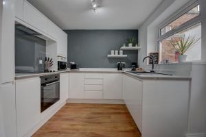 a kitchen with white cabinets and a large window at 38 George Street in Whitby