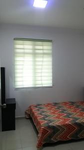 - une chambre avec un lit et une fenêtre avec des stores dans l'établissement Kasa Heights Homestay, à Malacca