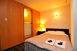 a bedroom with a bed with two towels on it at Comfesta Inn Kabe in Ome