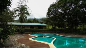 a swimming pool in front of a house at Malekus Mountain Lodge in Aguas Claras