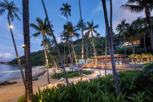 a beach with palm trees and a hotel at Four Seasons Resort Koh Samui - SHA Extra Plus in Mae Nam