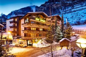 un hotel in montagna nella neve di notte di Hotel Butterfly, BW Signature Collection a Zermatt