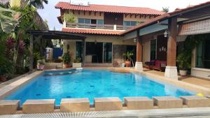 a swimming pool in front of a villa at Melaka Beachfront Villa with Pool in Melaka