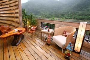 terraza de madera con mesa y sillas en el balcón en 香林茶園民宿 en Datong