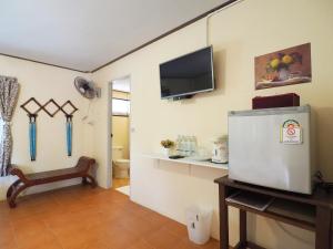 a living room with a television and a room with a chair at Baan Pun Sook Resort in Chao Lao Beach