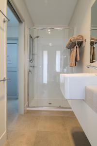 Un baño con ducha y lavabo blanco. en Cooper's Country Lodge, en Eromanga