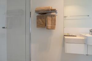 uma casa de banho com um chuveiro, um lavatório e toalhas em Cooper's Country Lodge em Eromanga