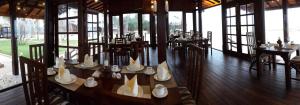 a dining room with tables and chairs and windows at Nilaveli Beach Resort - Level 1 Certified in Nilaveli