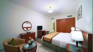 una habitación de hotel con una cama y una silla en Rose Garden Hotel Apartments - Bur Dubai, en Dubái