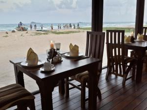 a dining room with a table with a view of the beach at Nilaveli Beach Resort - Level 1 Certified in Nilaveli