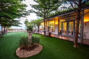 a garden in front of a building with trees at My Resort at Hua Hin by Charma in Hua Hin