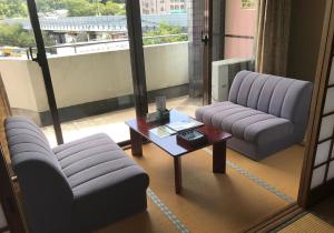 a living room with two chairs and a coffee table at Daikanso in Chikushino