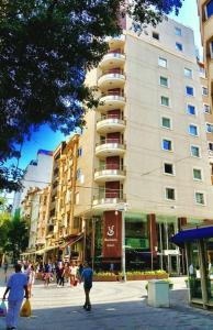 un edificio en una calle con gente caminando delante de él en SV Bussiness Hotel Taksim, en Estambul