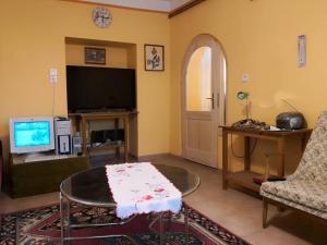 a living room with a coffee table and a tv at Nagymama Házikója in Tiszasas