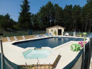 a swimming pool with chairs and a table at roquebrune in Saint-Alvère