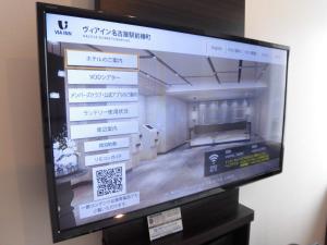 a television screen with a picture of a building at Via Inn Nagoya Station Tsubaki-cho in Nagoya