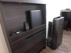 a wooden door with a television in a room at Via Inn Nagoya Station Tsubaki-cho in Nagoya