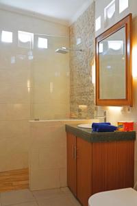 a bathroom with a sink and a shower with a mirror at Lebak Bali Residence in Canggu