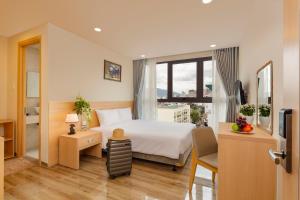 a hotel room with a bed and a window at The Swan Nha Trang Hotel in Nha Trang