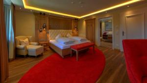 アンデクスにあるBoutique Hotel POST ANDECHSのベッドルーム1室(大型ベッド1台、赤いラグ付)