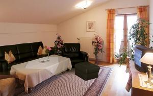 een woonkamer met een bank, een tafel en stoelen bij Landhaus Freiblick in Bodenmais