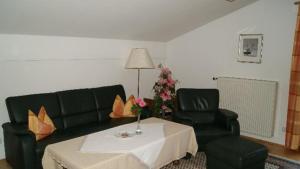 een woonkamer met een bank, een tafel en twee stoelen bij Landhaus Freiblick in Bodenmais