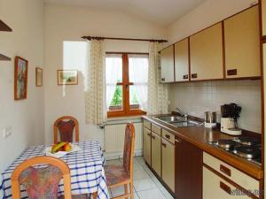 een keuken met een tafel en een wastafel en een tafel en stoelen bij Landhaus Freiblick in Bodenmais