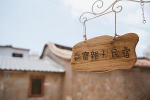 a wooden sign hanging in front of a building at Dan Bao Homestay in Jincheng