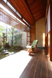 una stanza con una sedia e una grande finestra di Matsuharu ANN a Kyoto