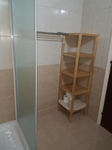 a bathroom with a shower with a wooden shelving unit at Flora Aparts in Dherinia