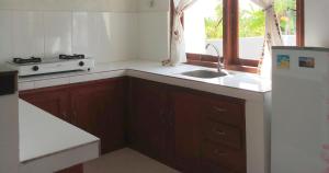 a small kitchen with a sink and a refrigerator at Villa das Meer 2BR Villa near Lovina Beach in Lovina