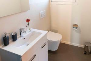 een badkamer met een witte wastafel en een toilet bij Au Chant du Vent in Tramelan