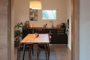 a kitchen with a table with chairs and a sink at Au Chant du Vent in Tramelan