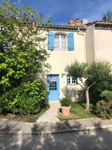 une maison avec une porte bleue et un arbre dans l'établissement Maison d'Azur, à Grimaud