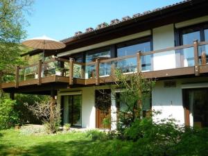 a large house with a deck and an umbrella at Traumzimmer im Pfälzer Wald in Neustadt an der Weinstraße