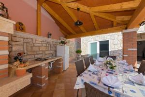 una sala da pranzo con un lungo tavolo e sedie di Villa Petra, Kaštelir a Kaštelir (Castellier)