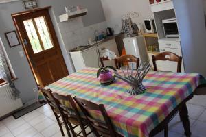 a kitchen with a table with a colorful table cloth at Les Perrières in Saint-Germain-la-Ville