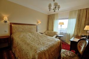 ブラーツクにあるHotel Taigaのベッドと椅子付きのホテルルーム