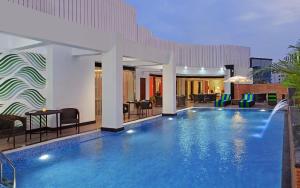 uma piscina num hotel com cadeiras e mesas em Fortune Park BBD - Member ITC Hotel Group em Lucknow