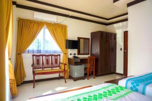 a bedroom with a bed and a desk and a chair at Veranda Hotel in Paoay