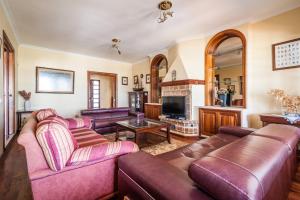 a living room with leather couches and a tv at Magnífica Villa al lado del mar in Arrecife