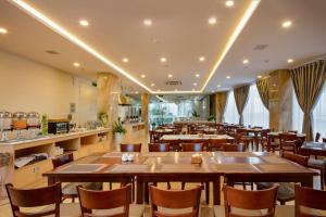 a restaurant with tables and chairs in a room at The Swan Nha Trang Hotel in Nha Trang