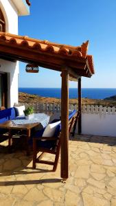 a patio with a table and chairs and the ocean at Iliatoras in Agia Pelagia