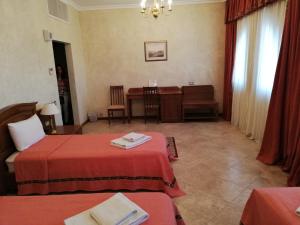 a hotel room with two beds and a table at Russian Pilgrim Residence in Sowayma