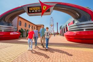 萨洛PortAventura Hotel Roulette - Includes unlimited access to PortAventura Park & 1 access to Ferrari Land的一群站在火车站前的人