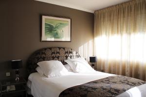 a bedroom with a bed and a window at Hostellerie Du Grand Saint Antoine in Albi