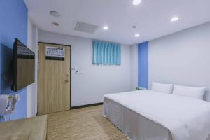 a hospital room with a bed and a door at Mei Ti Fashion Hotel in Zhongli +15 photos