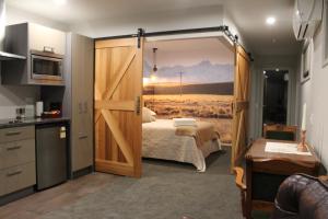 a bedroom with a bed and a sliding barn door at The Mackenzie Suites in Lake Tekapo