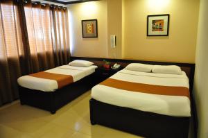 O Hotel في باكولود: سريرين في غرفة الفندق مع تنورات